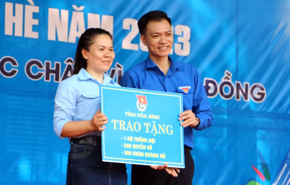 Anh Nguyễn Hoàng Sơn trao biển tượng trưng tặng tặng Liên đội trường Tiểu học và THCS Tòng Đậu. Ảnh: BTC