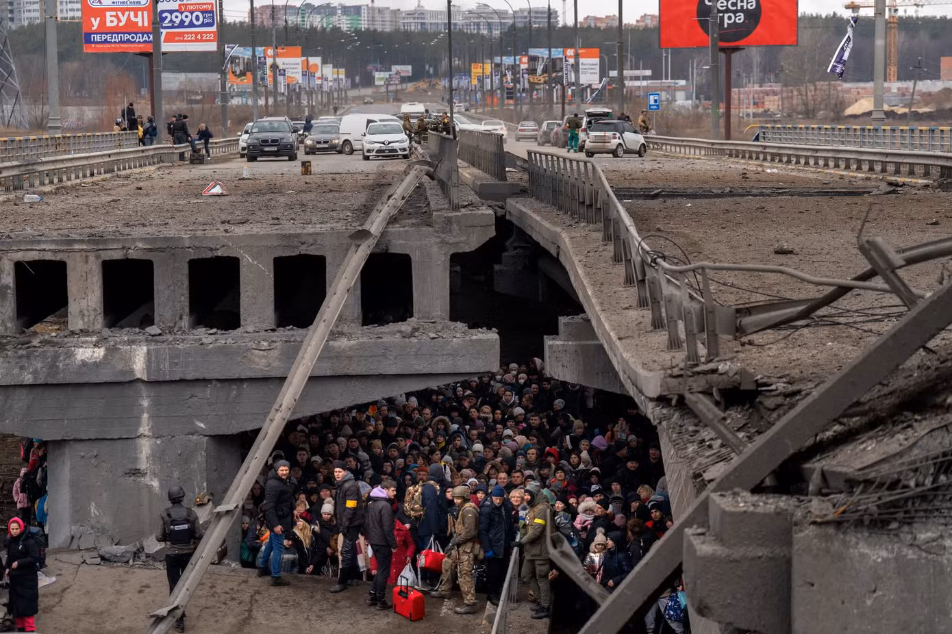 Người dân Ukraine tụ tập dưới một cây cầu khi họ cố gắng sơ tán qua sông Irpin ở ngoại ô Kiev vào ngày 5/3/2022. Cầu đã bị phá hủy để ngăn lực lượng Nga tiến vào thủ đô Ukraine. Ảnh: AP. Người dân Ukraine tụ tập dưới một cây cầu khi họ cố gắng sơ tán qua sông Irpin ở ngoại ô Kiev vào ngày 5/3/2022. Cầu đã bị phá hủy để ngăn lực lượng Nga tiến vào thủ đô Ukraine. Ảnh: AP.