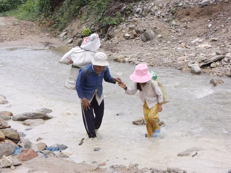 Mẹ con chị Hồ Thị Chùy cõng chuyến dắt díu nhau vượt qua suối . Mẹ con chị Hồ Thị Chùy cõng chuyến dắt díu nhau vượt qua suối