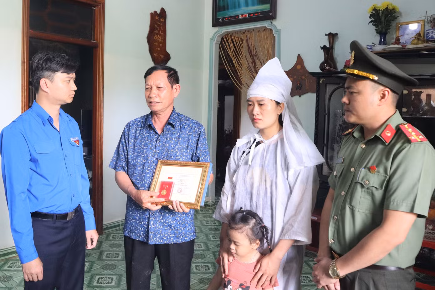 Anh Nguyễn Minh Triết trao Huy hiệu Tuổi trẻ dũng cảm truy tặng các liệt sĩ.