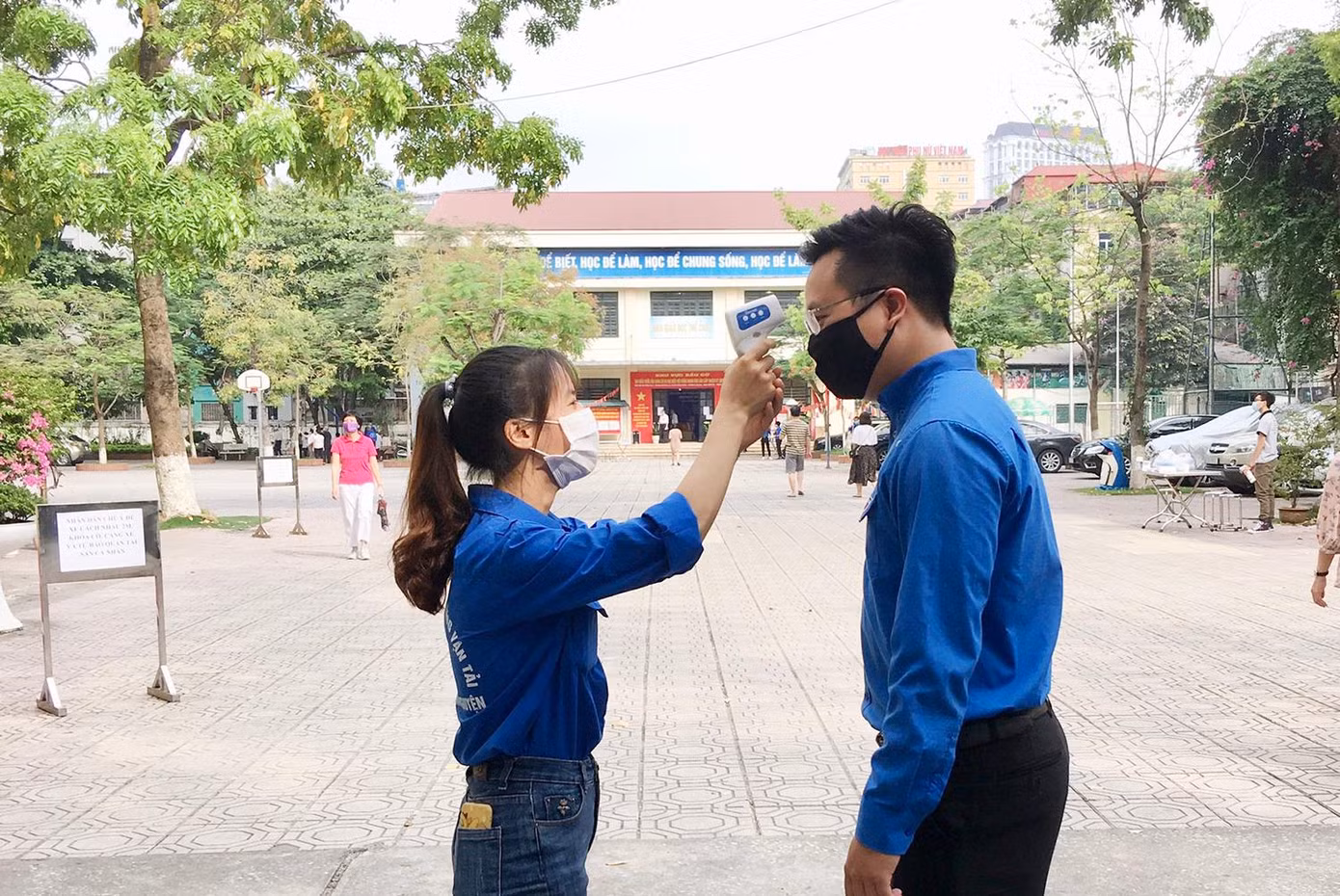 Tại điểm bầu cử, người dân được đo thân nhiệt tầm soát dịch COVID-19.