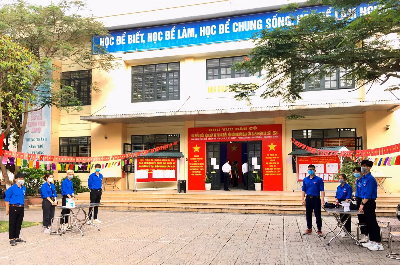 Thanh niên tình nguyện trang bị sẵn sàng khẩu trang, kính chống giọt bắn, máy đo nhiệt độ, nước sát khuẩn để đón tiếp người dân đến địa điểm bầu cử.