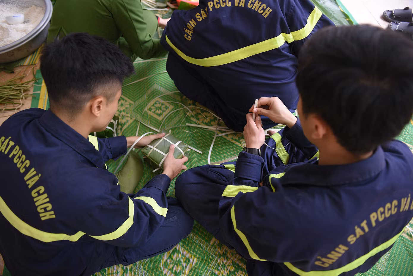 Đôi bàn tay các chiến sĩ không chỉ biết lái xe, cầm vòi chữa cháy mà còn khéo léo gói những tấm bánh chưng ngày Tết.
