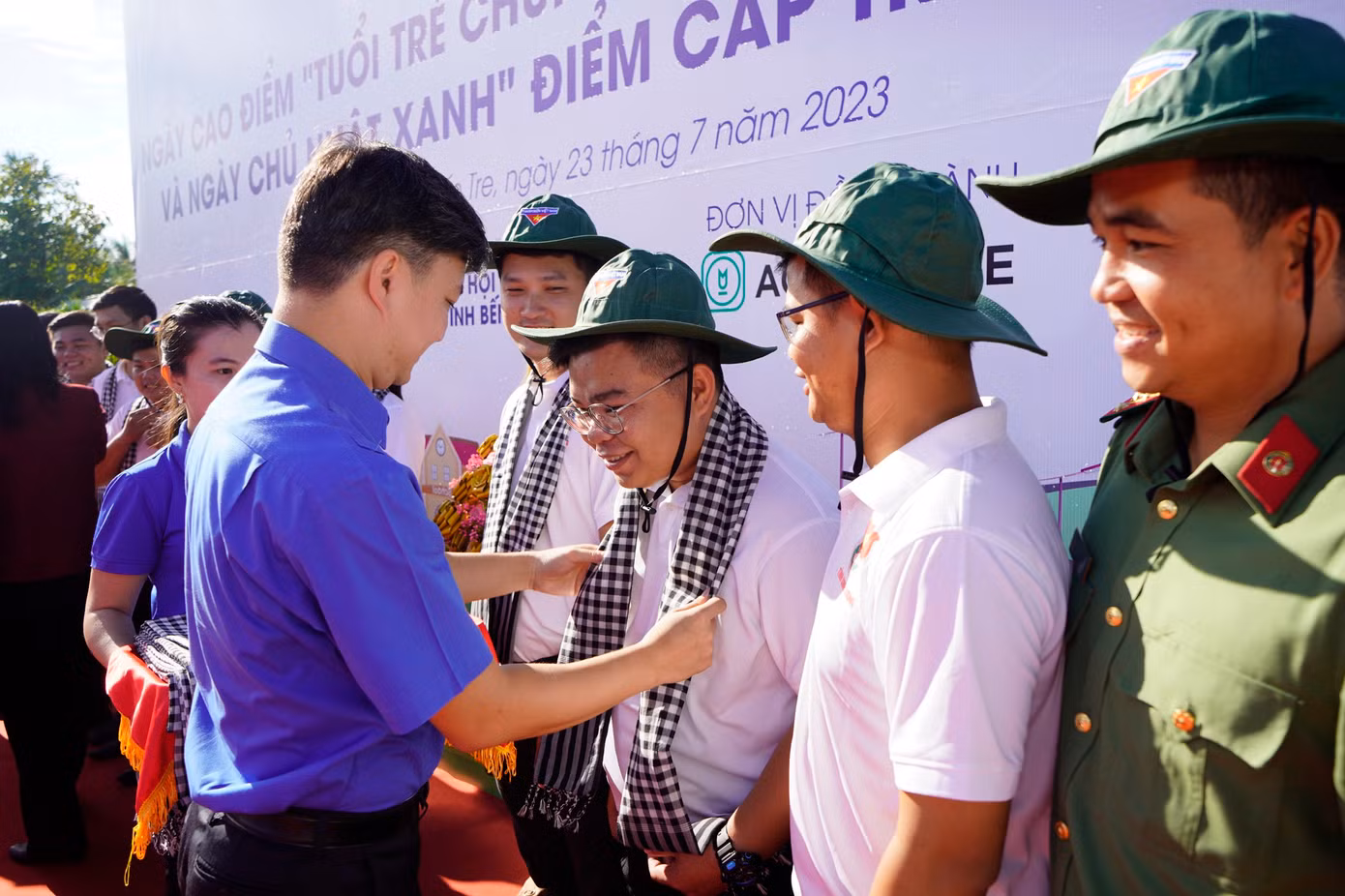 Anh Nguyễn Minh Triết trao tặng khăn cho Đội trí thức trẻ chuyển giao tiến bộ kỹ thuật cho thanh niên, người dân tại tỉnh Bến Tre.
