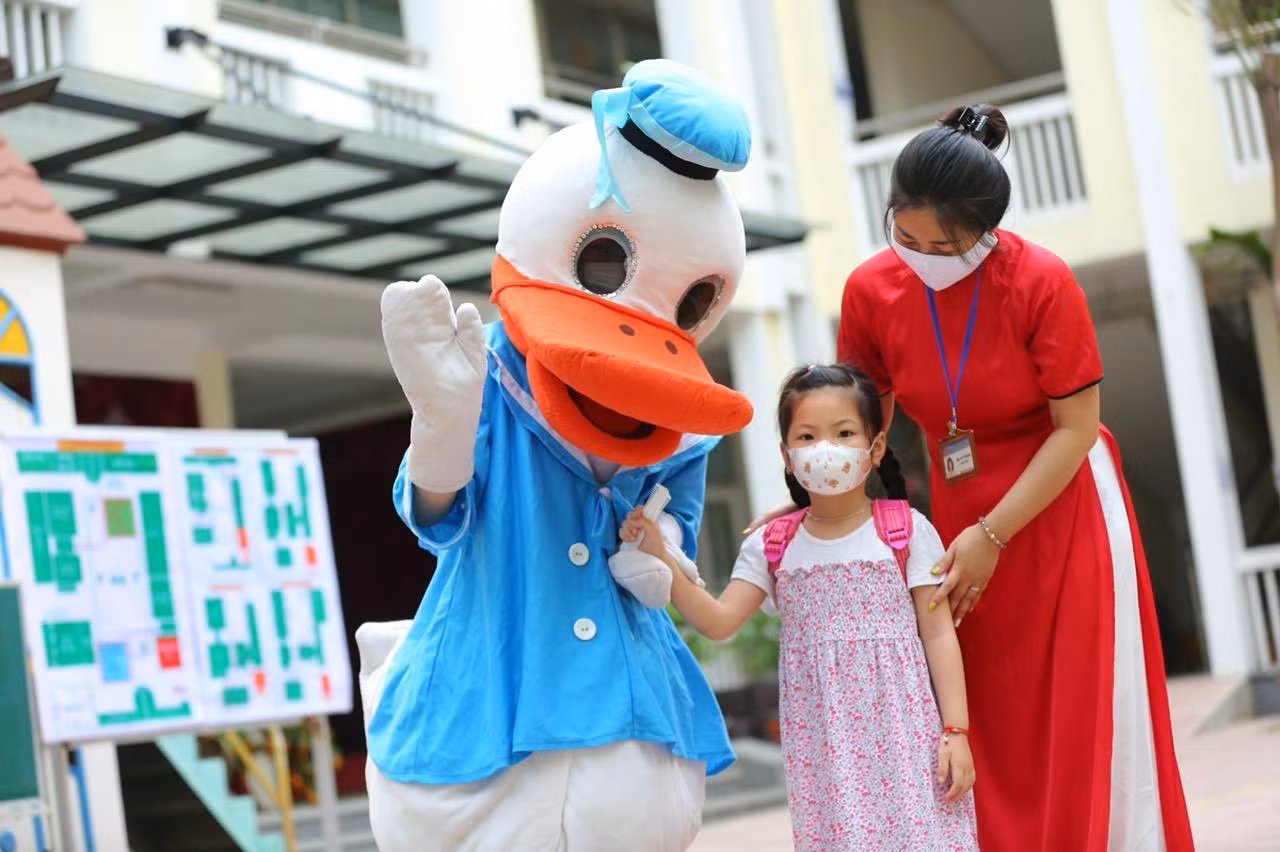 Tại 2 cổng chính và phụ, giáo viên trong trang phục hoá trang thành những chú vịt và gấu ngộ nghĩnh giúp các bạn nhỏ cảm thấy thân thuộc hơn, không còn bỡ ngỡ khi trở lại lớp học.