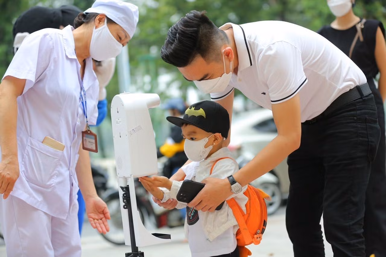 Trường mầm non Vân Hồ (quận Hai Bà Trưng) đã thực hiện nghiêm các biện pháp phòng, chống dịch, hướng dẫn cho các em đo thân nhiệt, sát khuẩn tay... ngay từ cổng trường.