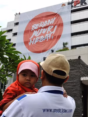 Người dân Indonesia xem khẩu hiệu chống tham nhũng tại trụ sở KPK hôm 25-11. Ảnh: Xinhua