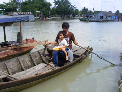 Đứa trẻ đeo túi khí ngồi trong lòng cha. Ảnh: L.Q.M