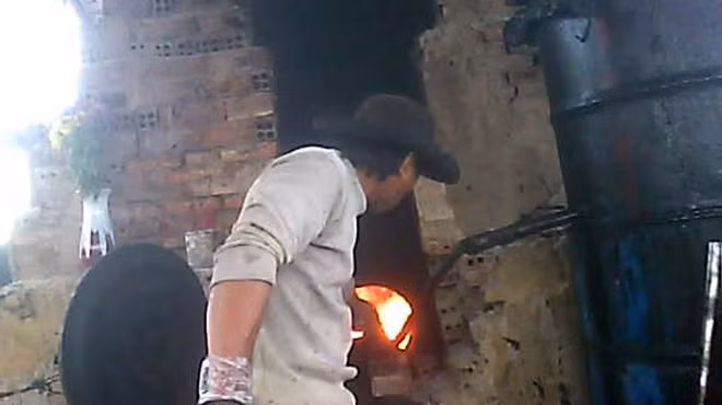 Thợ nấu dầu tại cơ sở của ông Hùng. Ảnh: Tuổi Trẻ
