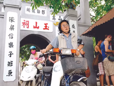 PGS.TS Hà Đình Đức và chiếc xe máy cà tàng tại Đền Ngọc Sơn. Ảnh: X.B