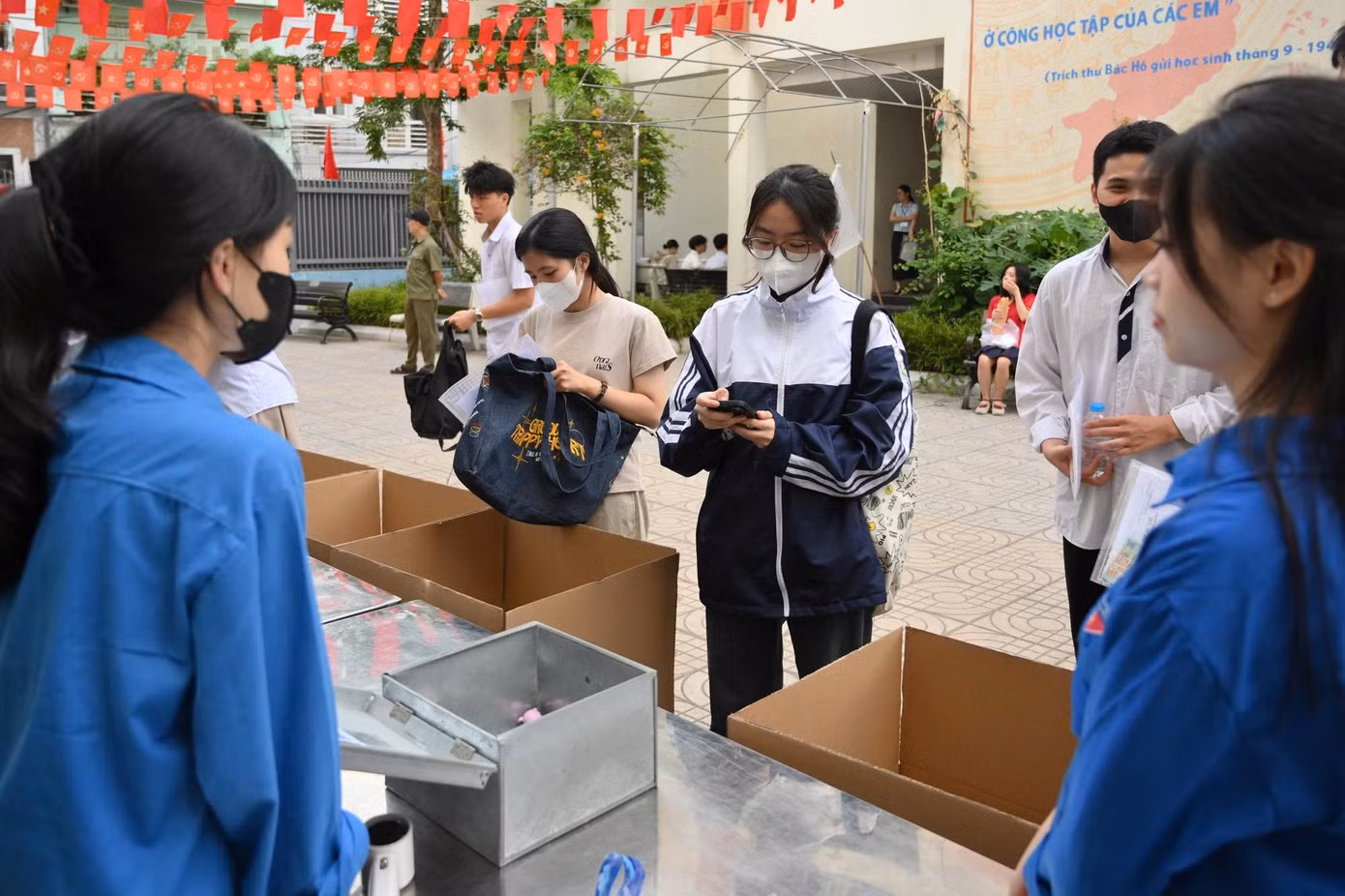 Bên trong sân trường, các giám thị lần lượt kiểm tra thông tin, hướng dẫn thí sinh ổn định chỗ ngồi.