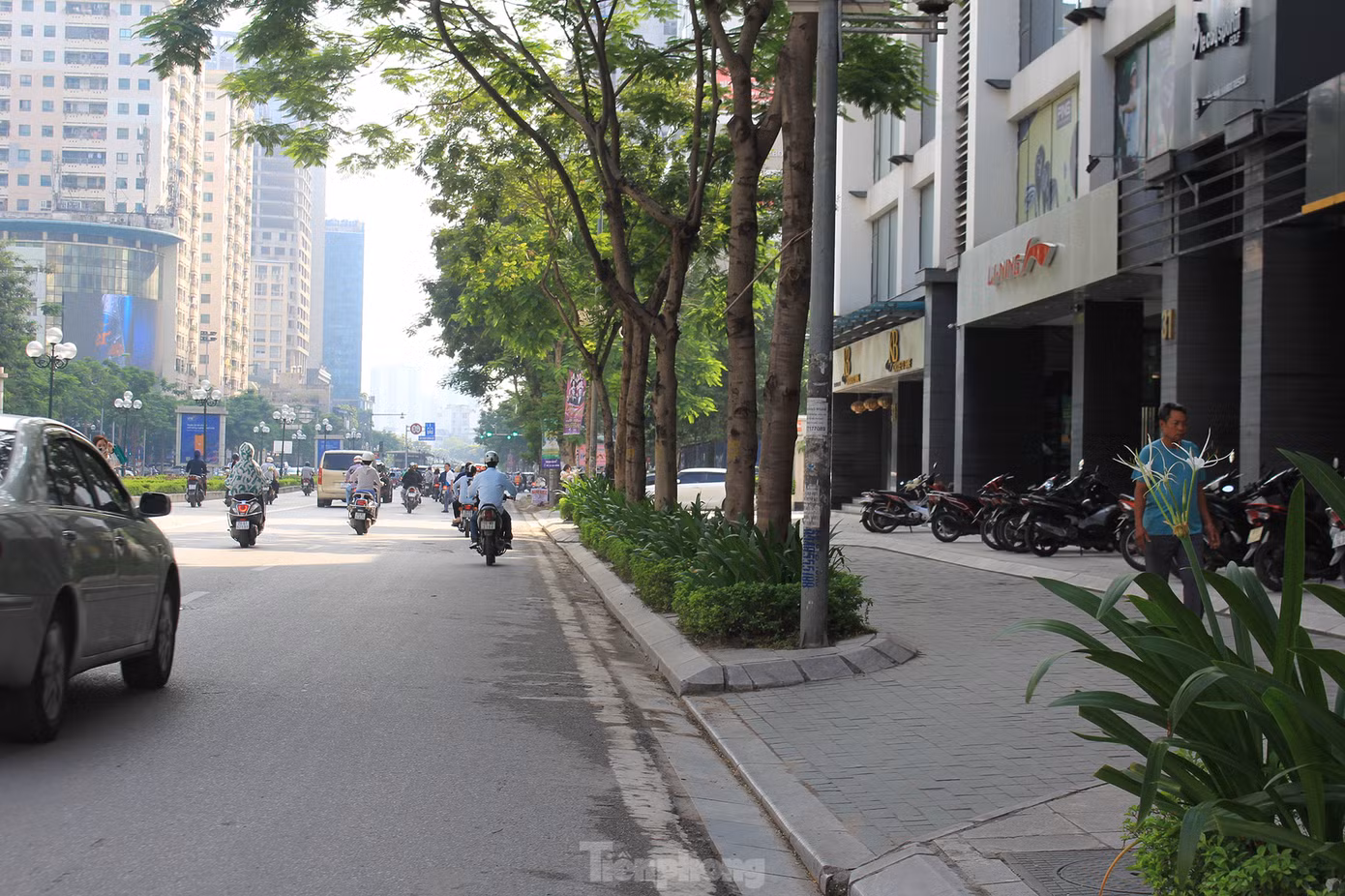 Nhiều dự án chung cư trên đường Lê Văn Lương (quận Thanh Xuân) tự ý san hạ cốt nền vỉa hè để làm lối đi riêng cho ô tô và xe máy vào tòa nhà. (Ảnh: Lập Đông)