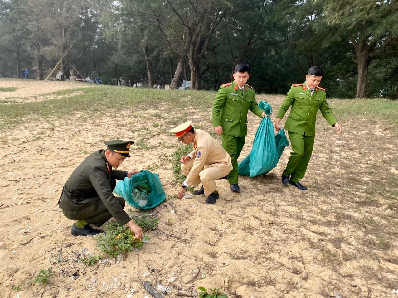 Các đoàn viên thanh niên Đoàn Công an huyện Quảng Trạch nhặt và thu gom rác thải trên bãi biển
