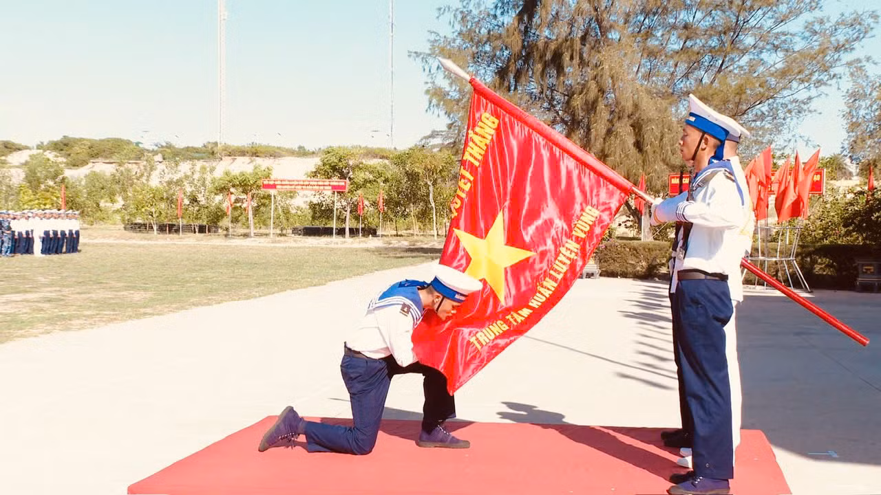 Chiến sĩ mới hôn Quân kỳ Quyết thắng tại Trung tâm Huấn luyện Vùng 4 Hải quân.