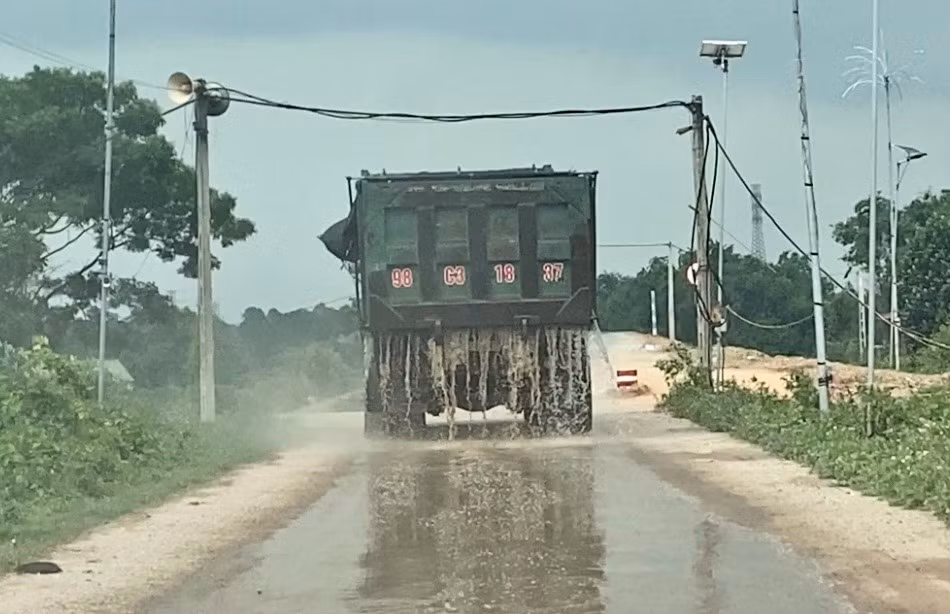 Xe tải di chuyển từ bãi tập kết cát chảy nước xuống đường.