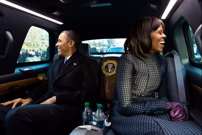Vợ chồng ông Obama cười tươi khi ngồi trong ô tô tham dự cuộc diễu hành ở Washington D.C hôm 21/1/2013
