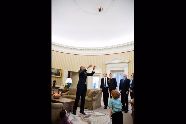 Ngay cả trong phòng làm việc, tổng thống Obama vẫn ném bóng bầu dục đùa cùng với thành viên chính phủ và một cậu bé