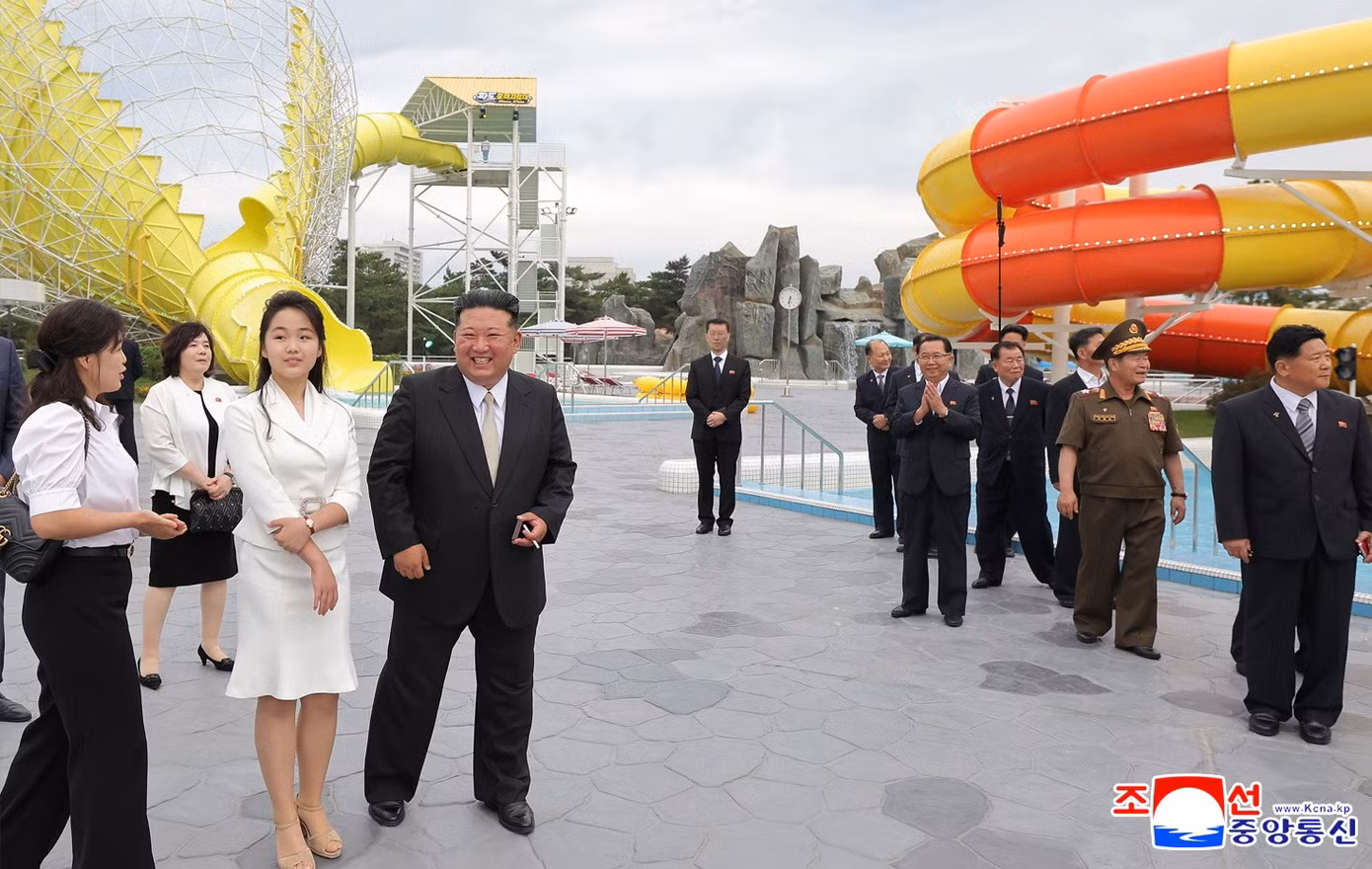 Những bức ảnh do hãng thông tấn Trung ương Triều Tiên (KCNA) công bố cho thấy, bà Ri đứng cạnh ông Kim và con gái Ju-ae trong buổi lễ ngày 24/6. Bà Ri mặc áo sơ mi trắng, quần dài đen. Còn con gái ông Kim mặc bộ váy màu trắng thanh lịch. (Ảnh: KCNA)