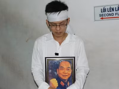 Nguyễn Đình Phương ôm di ảnh Đại tướng Võ Nguyên Giáp ra ga Sài Gòn cho kịp chuyến tàu khởi hành lúc 12 giờ. Ảnh: Huy Thịnh