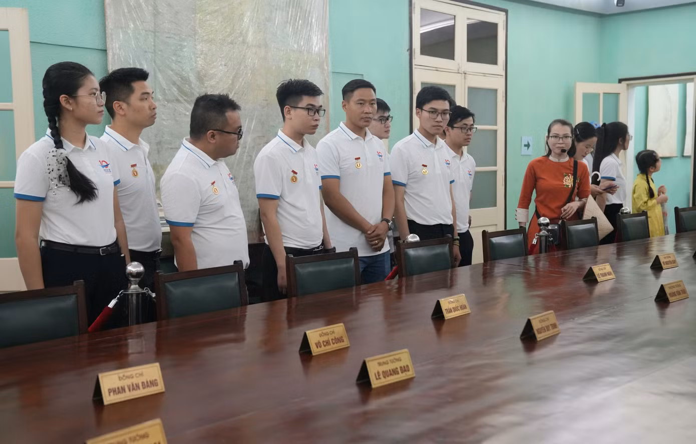 Các gương mặt trẻ chăm chú lắng nghe thuyết minh viên khi tham quan Hoàng thành Thăng Long.