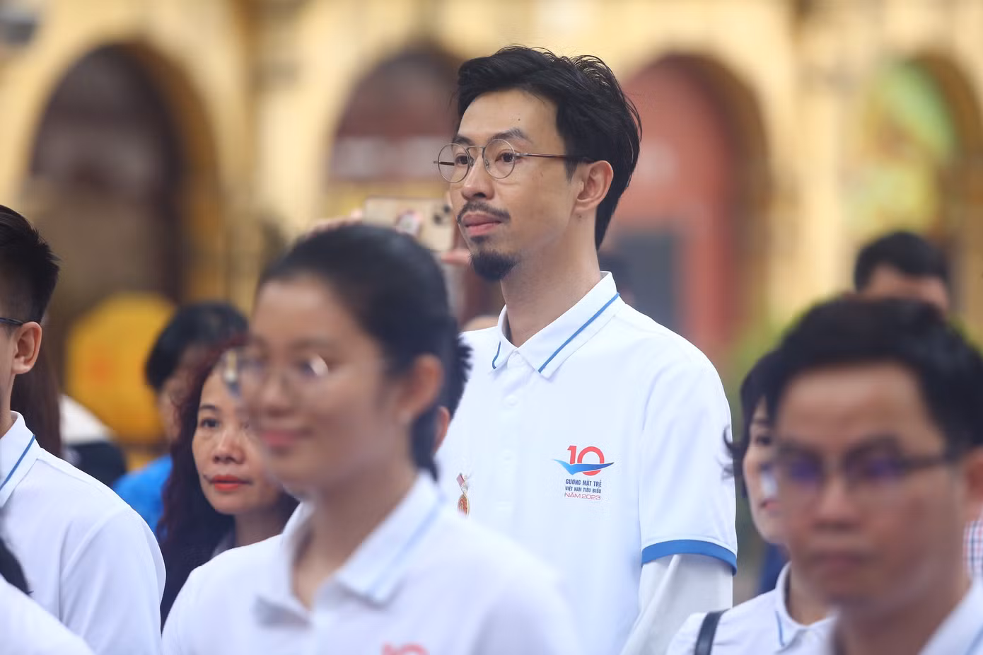 Các gương mặt trẻ chăm chú lắng nghe thuyết minh viên khi tham quan Hoàng thành Thăng Long.