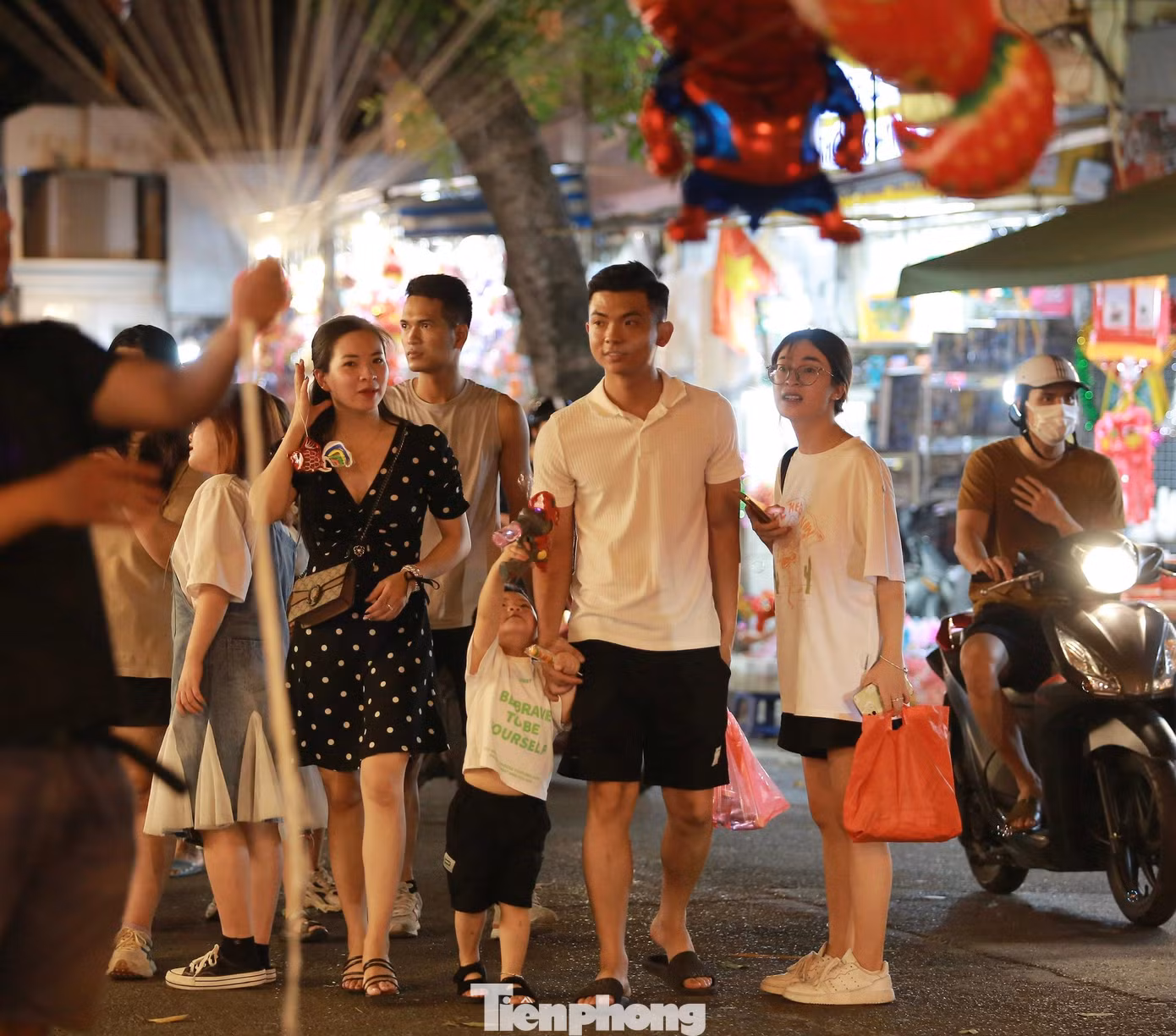 Các em nhỏ được bố mẹ đưa đi chơi tại phố Hàng Mã.