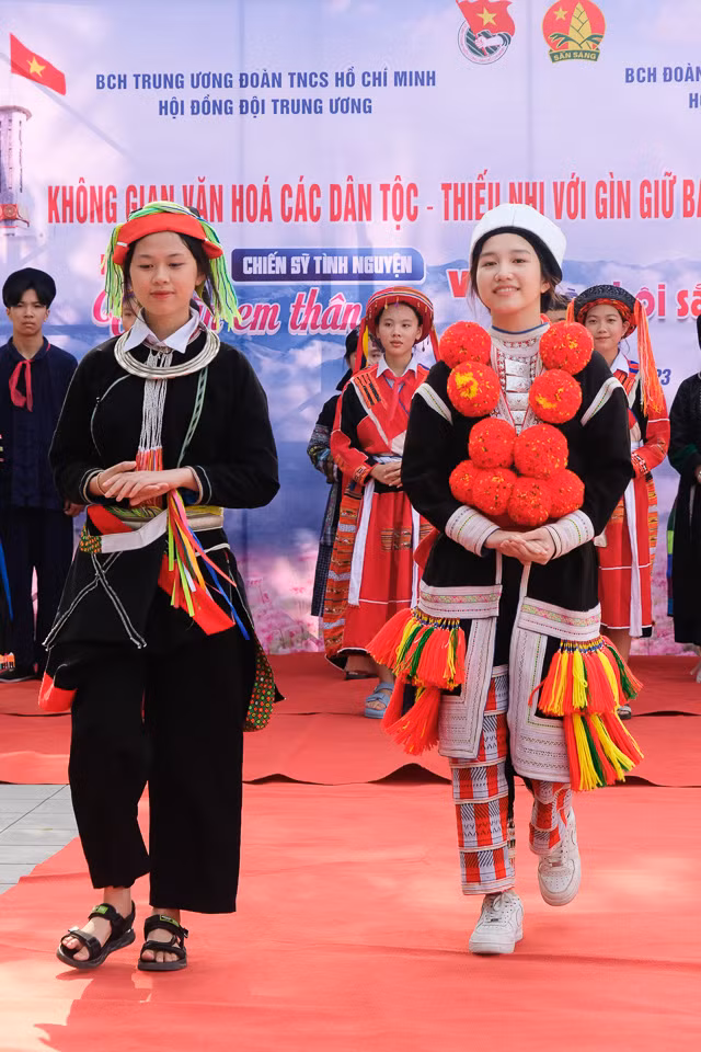 Trang phục Dao đỏ - Dao áo dài được trình diễn bởi 2 em đến từ Hội đồng Đội thành phố Hà Giang. Hiện nay, dân tộc Dao chiếm 14,9% so với dân số trong toàn tỉnh, chủ yếu sinh sống tại các huyện phía Tây. Sự đặc sắc trong văn hóa của người dân tộc Dao được thể hiện qua làn điệu dân ca, hát giao duyên rất phong phú, đa dạng trong cúng thần rừng, cúng đầu năm mới, trong lễ hội, tảo mộ…
