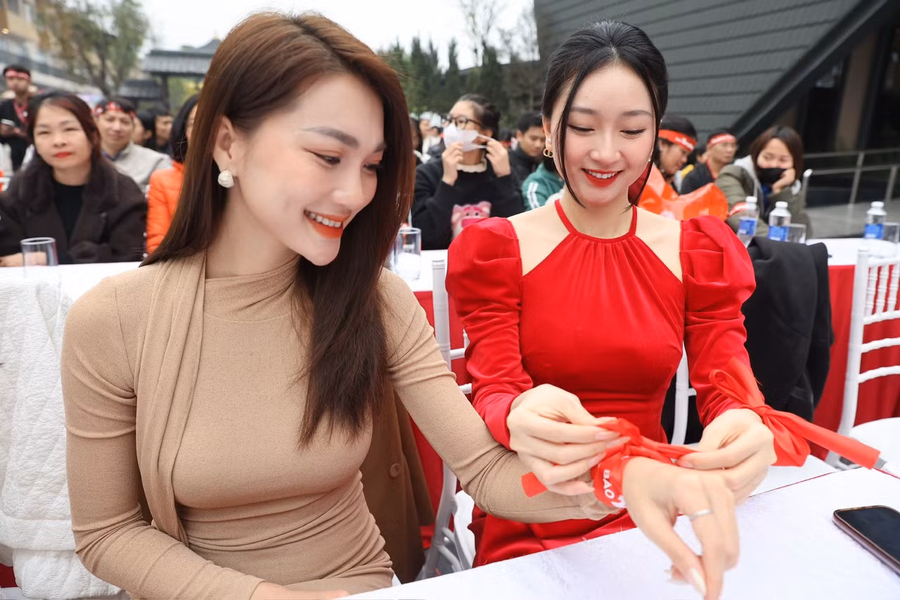 Kim Trà My buộc ruy băng Chủ Nhật Đỏ cho Top 10 Hoa hậu Hoàn vũ Việt Nam 2017 Nguyễn Ngọc Nữ.