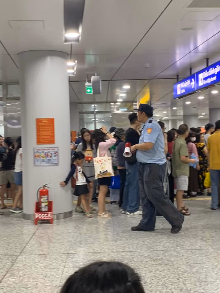 Người đi tàu chụp hình "người khổng lồ" của Metro. Ảnh: Đinh Huỳnh Ngọc Hằng, Bình Minh Người đi tàu chụp hình "người khổng lồ" của Metro. Ảnh: Đinh Huỳnh Ngọc Hằng, Bình Minh