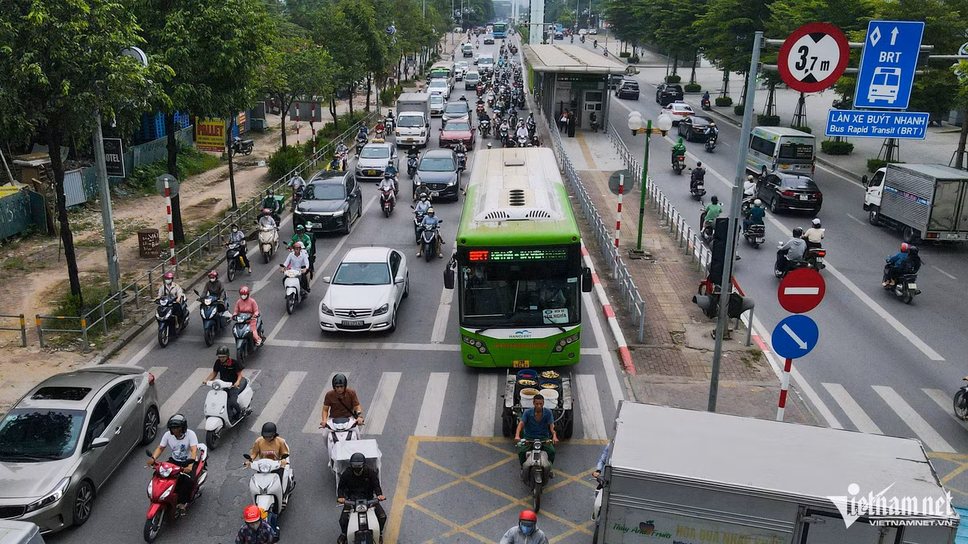 Xe buýt nhanh chật vật di chuyển trên làn đường riêng. Cả phía đầu và đuôi xe đều bị các phương tiện 'bủa vây'.