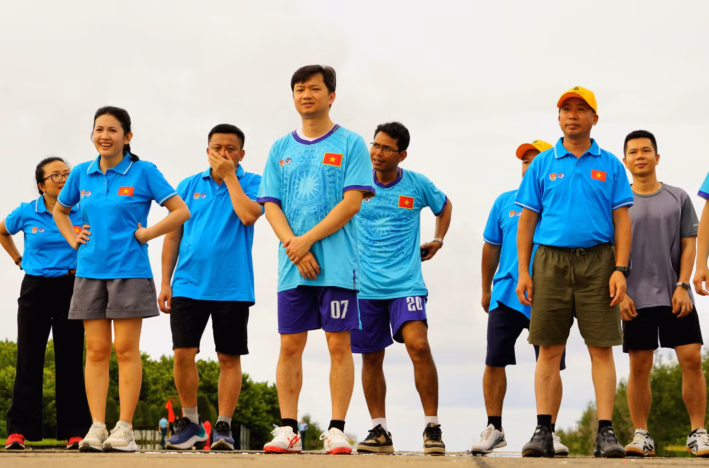 Các vận động viên chăm chú nghe phổ biến thể lệ giải chạy.