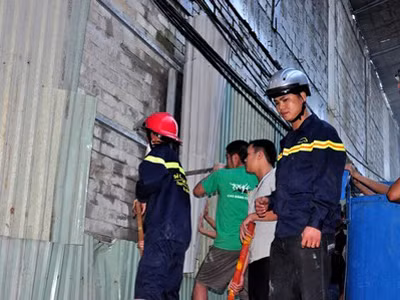 Dùng búa đục tường phía sau khu vũ trường - khách sạn đang xây dựng để đưa nước vào chữa cháy