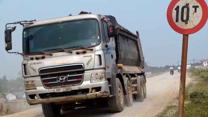 Xe tải trọng lớn chạy trên đường giới hạn tải trọng 10 tấn đoạn qua xã Hải Bối, Đông Anh, Hà Nội - Ảnh: Tiến Thắng