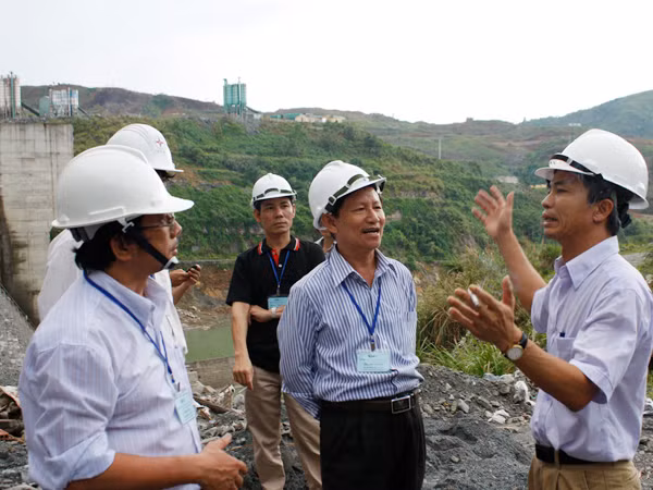 Ông Trần Văn Hải (phải) giải thích với các chuyên gia về thiết kế đập Sông Tranh 2 