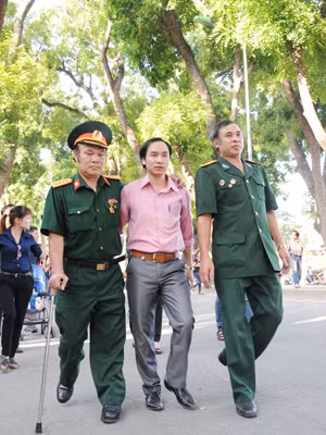 Đại úy Lê Long Triệu – Thương binh hạng ¼ đặc biệt (chống nạng, bên trái) cùng đồng đội vào viếng Đại tướng