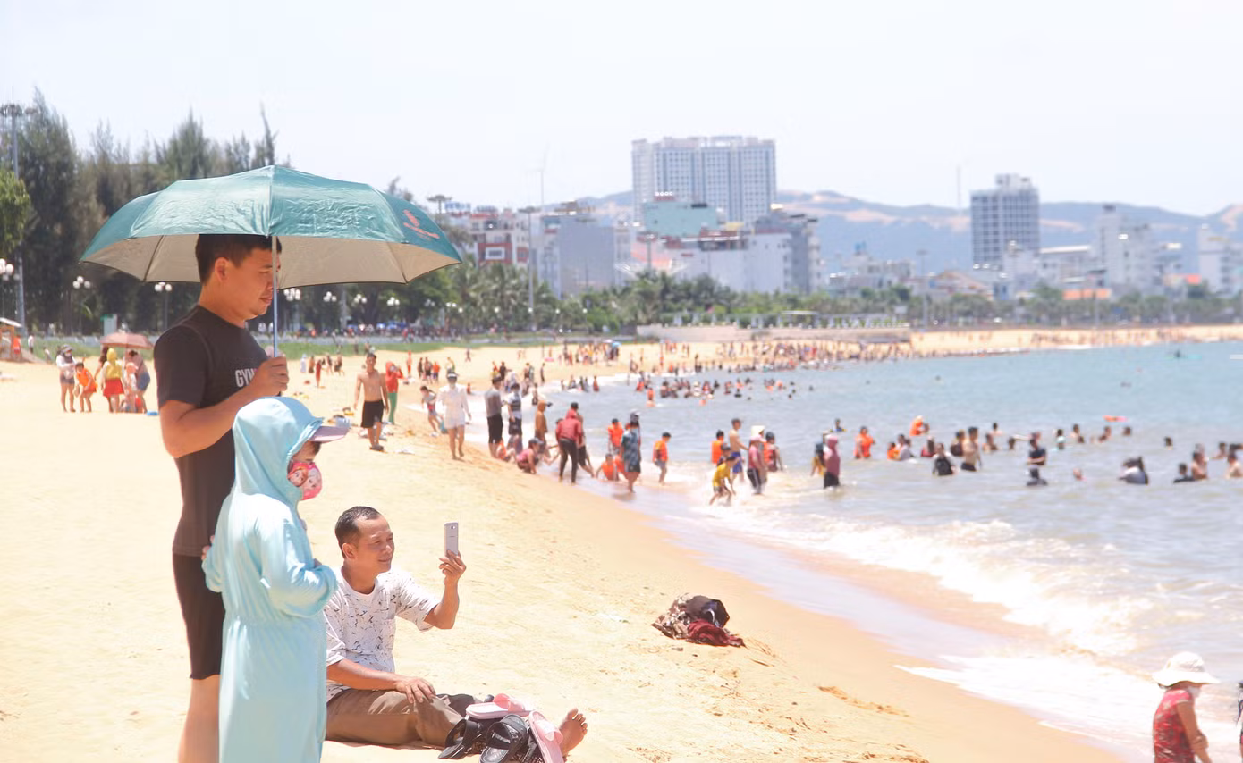 Theo ghi nhận, 12h trưa, hàng ngàn người dân từ người già, thanh thiếu niên cho đến trẻ em kéo nhau xuống biển tắm. Ảnh: Trương Định
