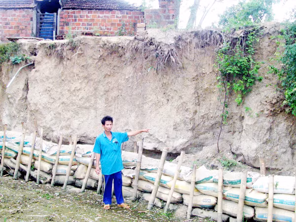 Thủy điện xả nước khiến đất lở đến tận vách nhà dân. Ảnh: V.H