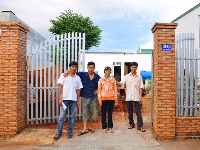 Mẹ con bà Khoa trước căn nhà mới