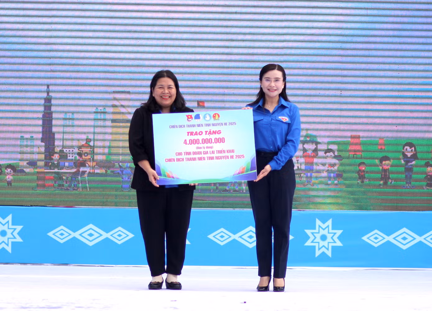Chị Nguyễn Phạm Duy Trang (phải) trao bảng tượng trưng 4 tỷ đồng cho Bí thư Tỉnh Đoàn Gia Lai Hà Thị Giang Thảo triển khai Chiến dịch Thanh niên tình nguyện Hè năm 2025.
