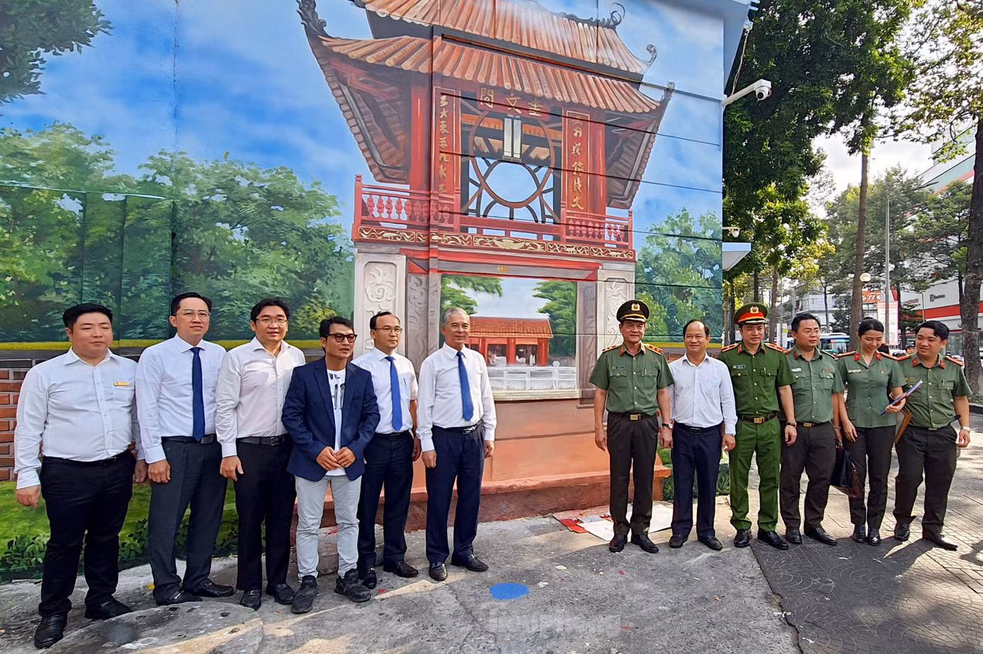 Lãnh đạo UBND và Công an TPHCM chụp hình lưu niệm tại công trình bích họa ở quận 1. Ảnh: Hoàng Thuận.