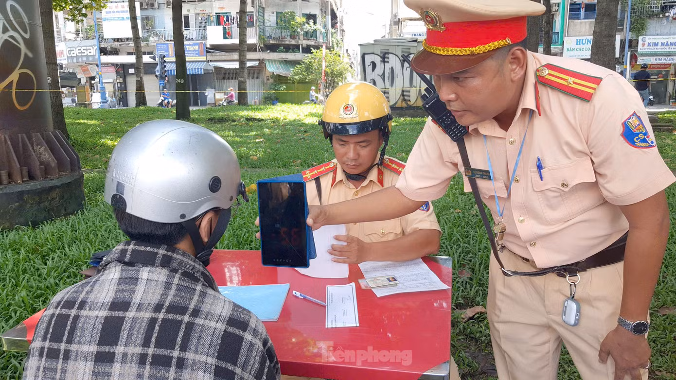 Trước khi lập biên bản, lực lượng CSGT thông báo tốc độ mà người đi xe máy vi phạm. Ảnh: Hoàng Thuận