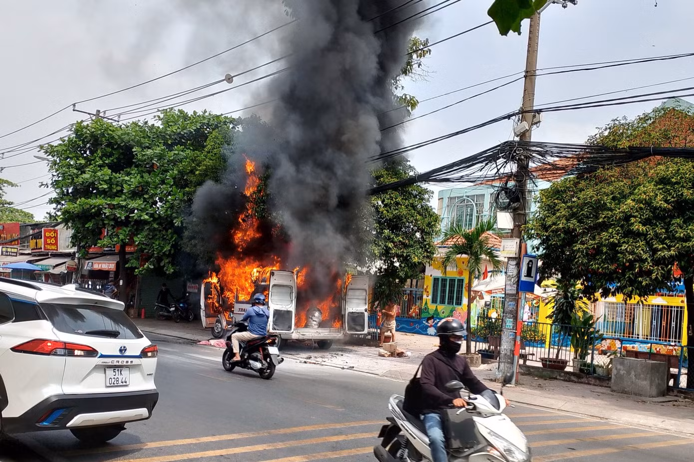 Lửa bao trùm ô tô 16 chỗ. Ảnh: H.T. Lửa bao trùm ô tô 16 chỗ. Ảnh: H.T.