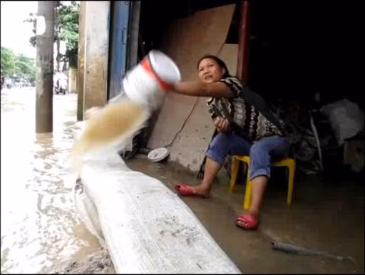 "Tát xong, ô tô đi qua là nước lại tràn vào nhà". Ảnh: Trường Phong.