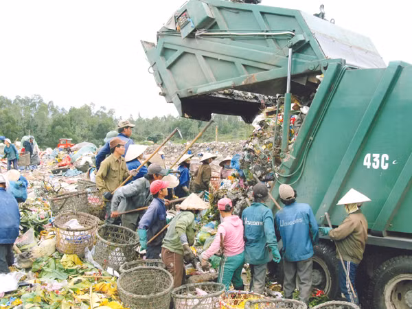 Đổ xô lượm rác khi xe đến. Ảnh: Nam Cường
