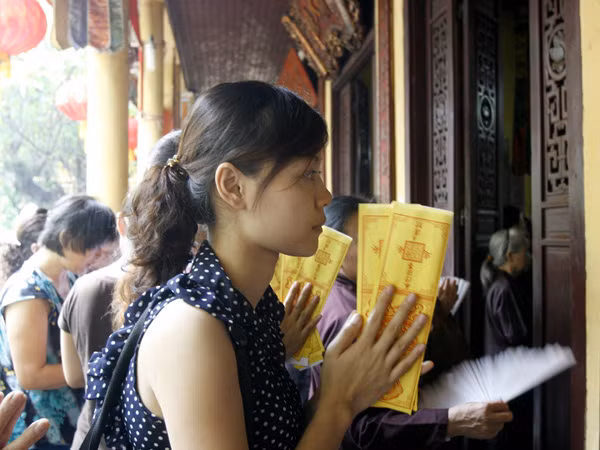 Vàng mã được cầm trên tay để cầu may. Vàng mã được cầm trên tay để cầu may