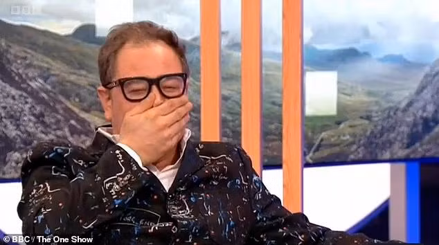 Alan Carr che miệng vì sốc và buồn cười. Alan Carr che miệng vì sốc và buồn cười.