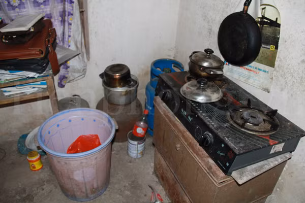 Trong nhà, chỉ có duy nhất chiếc bếp gas là đáng giá nhất. Đó là đồ vật được mua bằng tiền học bổng của Đích. Bên cạnh chiếc bếp gas là thùng gạo mở nắp, chỉ còn lại một ít. Ảnh: Trường Phong