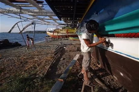 Một ngư dân Philippines sơn lại tàu cá của mình