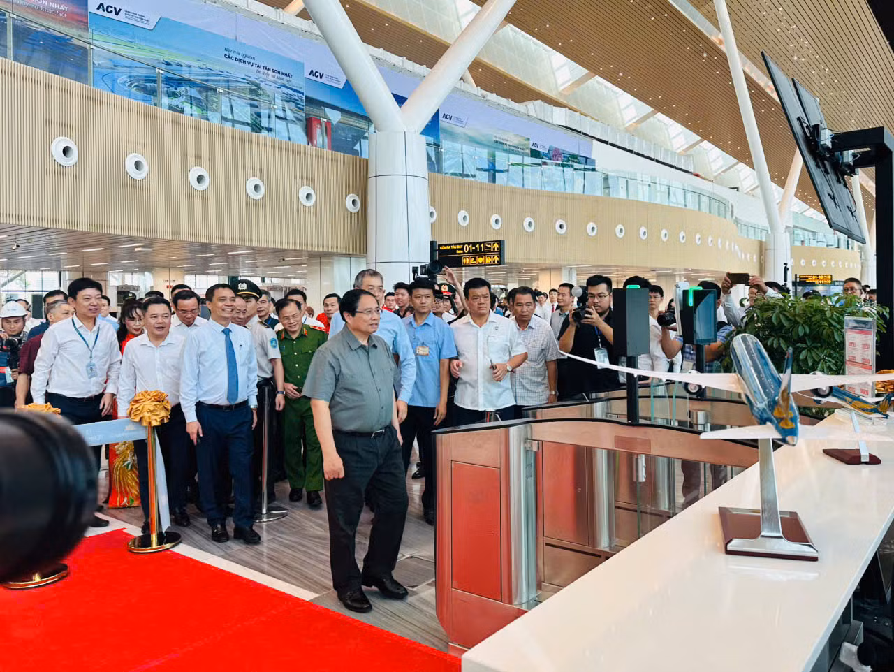 Trước thời điểm máy bay cất cánh, Thủ tướng Phạm Minh Chính cùng lãnh đạo các bộ, ban, ngành đã đến cửa ra máy bay số 12 của chuyến bay VN244 để trực tiếp kiểm tra quy trình làm thủ tục lên máy bay bằng công nghệ sinh trắc học, tích hợp trong ứng dụng VNeID. Ảnh: VNA.