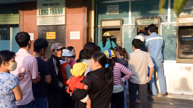 Người dân xếp hàng chờ rút tiền từ máy ATM ở Khu công nghiệp Long Thành, Đồng Nai